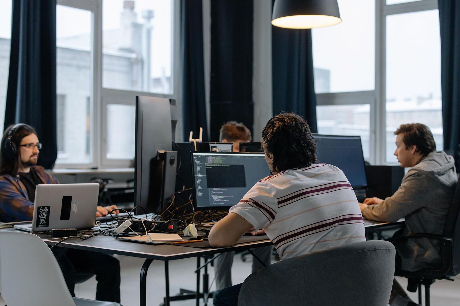 NGN engineers working side by side at a row of monitors